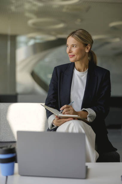 istock Confident female manager making notes in note pad sitting on modern office background 1706439439
