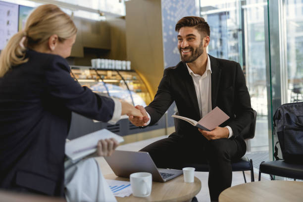 istock Smiling business partners shaking hands after concluding deal while sitting in cafe 1706447031