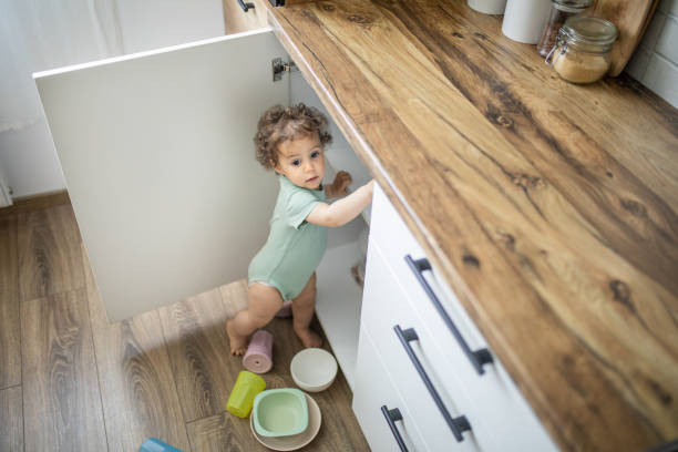 милый ребенок играет с кухонной утварью на домашней кухне - domestic kitchen accessibility open drawer сто�ковые фото и изображения