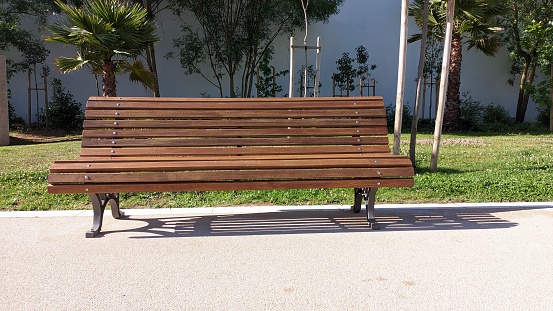 A bench in a public park in Lisbon near a high white wall photo