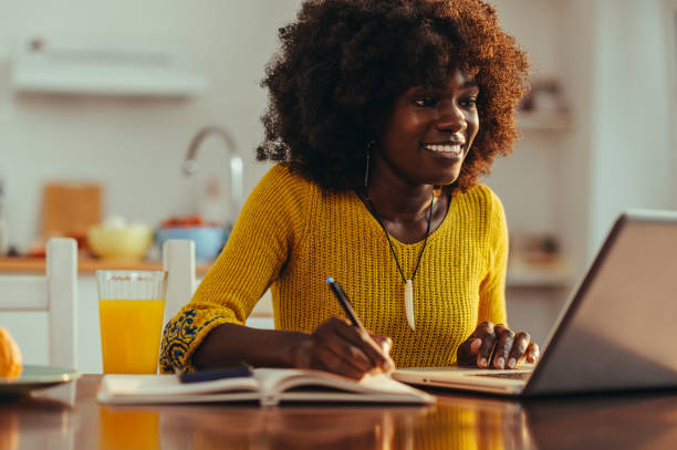 istock A cheerful african american female freelancer is writing down notes and tasks 1706458793