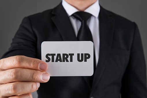 Businessman is showing his business card with start up message