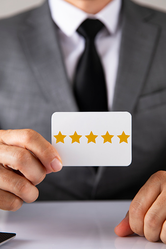 Businessman is holding five star rating card