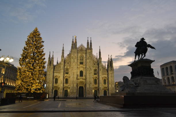 istock Milan Duomo square with the main Cathedral facade and decorated Christmas tree on blue sky background at dawn. Runrise lights. 1706475274