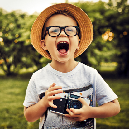 Happy little photographer with vintage camera