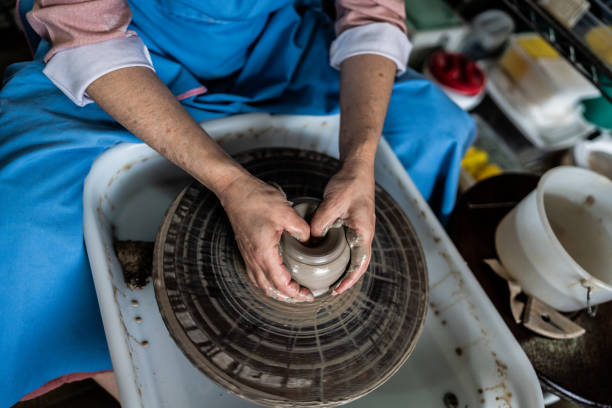 istock Potter's hands modeling clay in a potter wheel at a ceramics studio 1706484343
