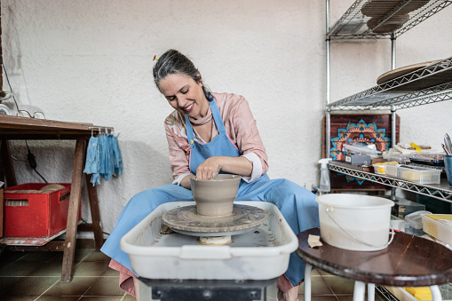 Potter modeling clay in a potter wheel at a ceramics studio