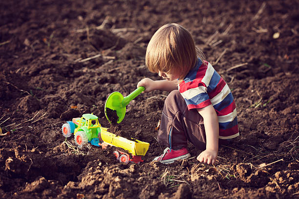 istock Little boy playing with a toy tractor 170648687