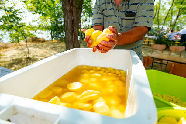 istock Old hands hold fresh peel clean young potatoes 1706495318