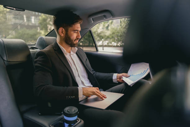 istock Male entrepreneur sitting on car backseat and working with documents while going to office 1706496976