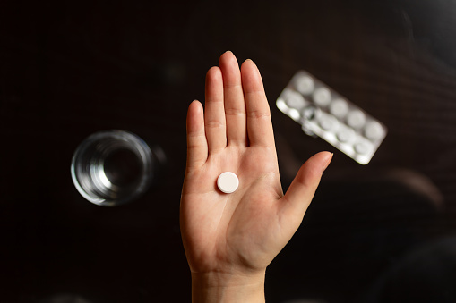 Close-up of hand holding a pill