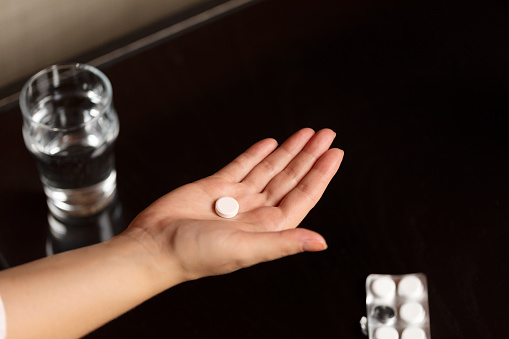 Close-up of hand holding a pill