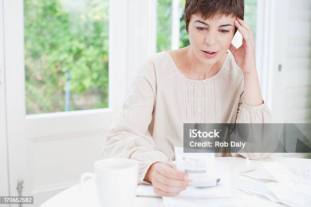 Woman Paying Bills And Looking Worried Stock Photo - Download Image Now - Finance, 30-39 Years, 35-39 Years