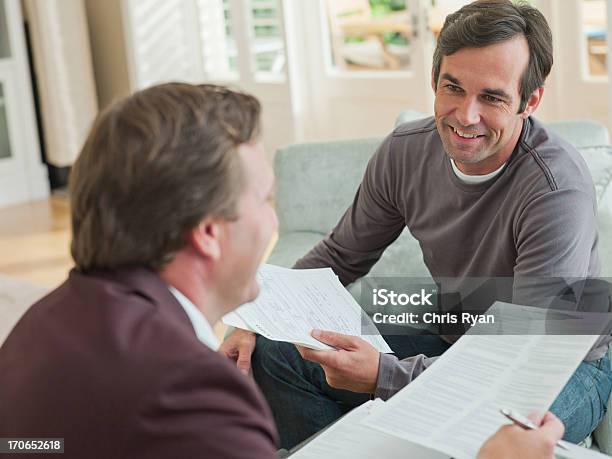 Homem Reunião Com Um Consultor Financeiro Na Sala De Estar - Fotografias de stock e mais imagens de Conselho