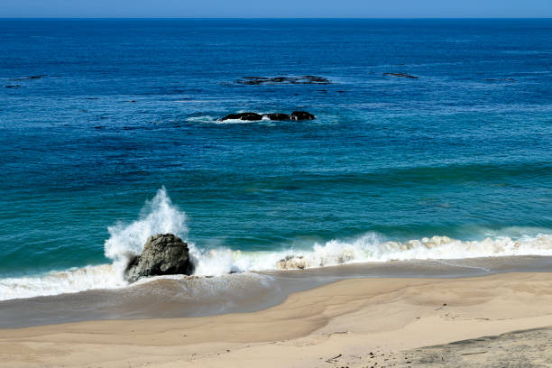 Wide view of waves crashing on shore rocks of Garrapata Beach.\n\nTaken at Garrapata Beach, Big Sur, California, USA