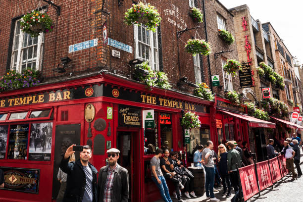 Tourists Taking a Selfie at Temple Bar Pub in Dublin, Ireland Dublin, Ireland - May 21, 2016. Tourists taking a selfie at Temple Bar Pub at Temple Bar district in downtown Dublin the capital of Ireland. temple bar pub stock pictures, royalty-free photos & images
