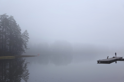 Foggy early morning on lake, wooden pier, horizontal picture
