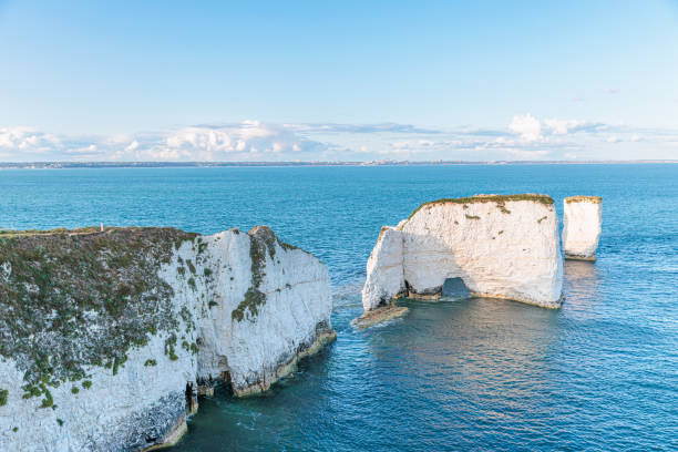 vue imprenable sur les célèbres old harry rocks, le point le plus oriental de la côte jurassique, un site du patrimoine mondial de l’unesco, royaume-uni. heure dorée du soir - jurassic coast world heritage site photos photos et images de collection