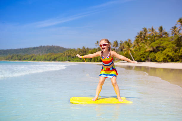 istock Child surfing on tropical beach. Surfer in ocean. 1706653715