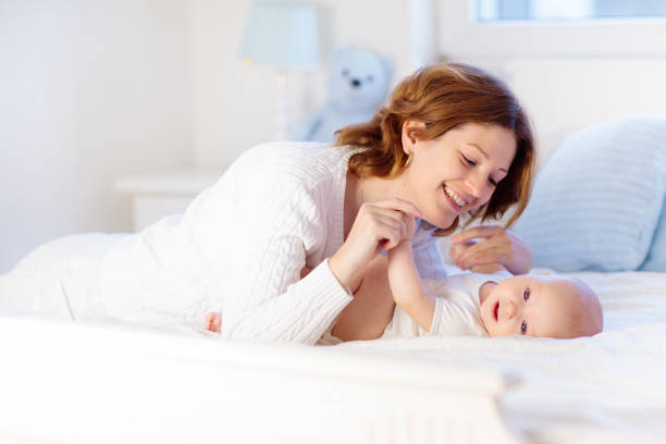 istock Mother and baby on a white bed 1706654787