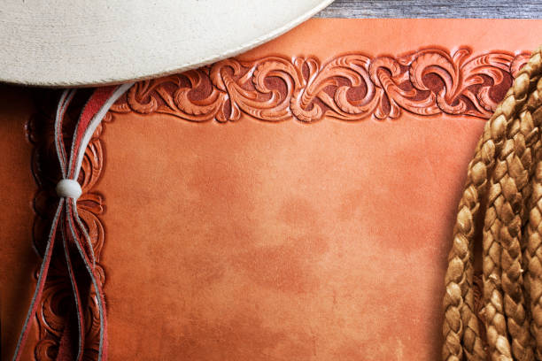 istock Stampede String Of Cowboy Hat And Lasso On A Tooled Leather Surface 1706655864
