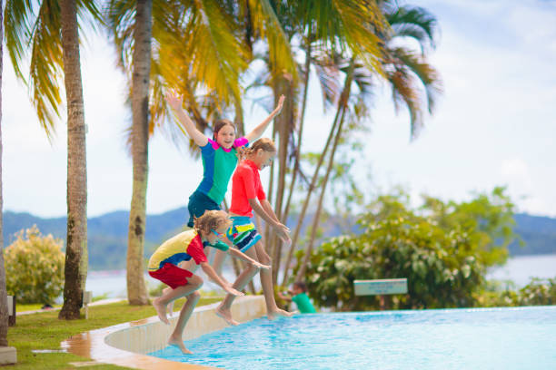 istock Kids jump into swimming pool. Summer water fun. 1706659054