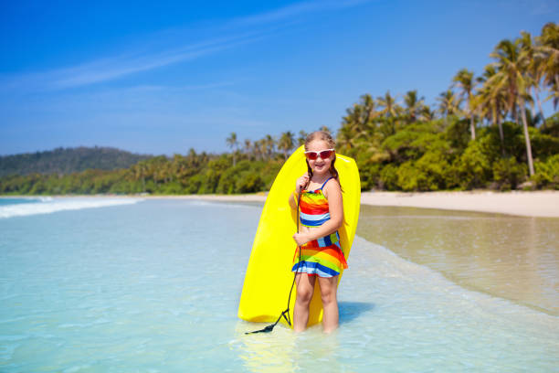 istock Child surfing on tropical beach. Surfer in ocean. 1706667656