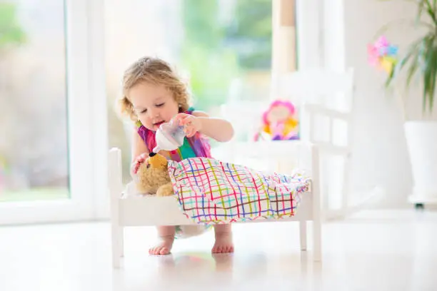 Photo of Child playing with teddy bear toy. Kids play.