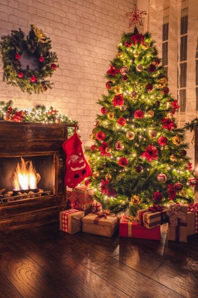 Decorated Christmas tree near fireplace at home stock photo