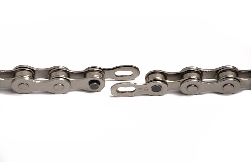 bicycle chain disconnected at the chain master link (connector pin) isolated on white background (close up macro cut out of bike chain) cycling, bike parts, biking