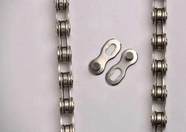 bicycle chain disconnected lying next to chain master link (connector pin) isolated on white background (close up macro cut out of bike chain) cycling, bike parts, biking