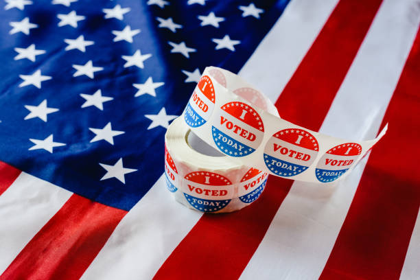 istock I vote today stickers roll, in US elections on American flag. 1706688189