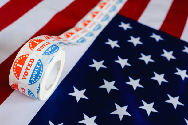 istock I vote today stickers roll, in US elections on American flag. 1706688198