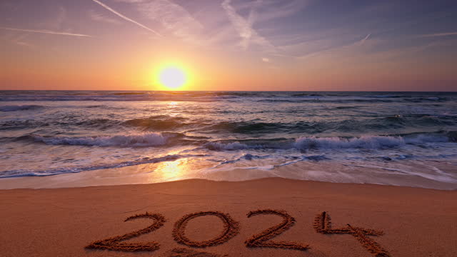 Sea horizon, morning on tropical beach and text happy new year 2024 on sand