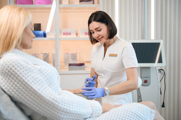 istock Happy beautician performing injection on client wrist 1706716354