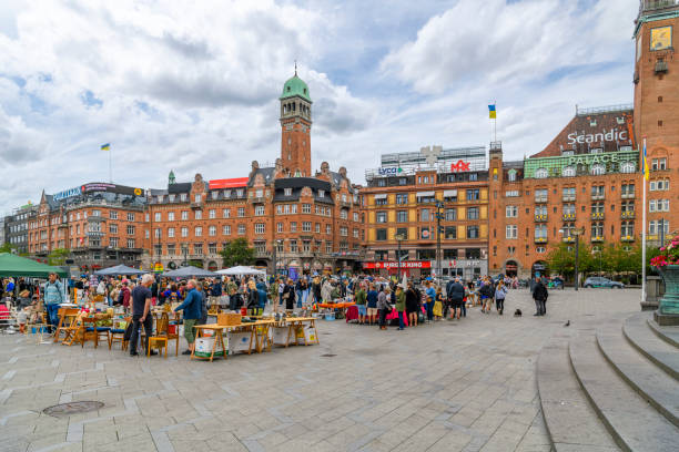 Local Danish and tourists browse the vendors and kiosks selling gifts, collectibles and souvenirs at the Copenhagen City Hall Square in front of the City Hall building in Copenhagen, Denmark. Local Danish and tourists browse the vendors and kiosks selling gifts, collectibles and souvenirs at the Copenhagen City Hall Square in front of the City Hall building in Copenhagen, Denmark.  Its large size, central location, and affiliation with the city hall makes it a popular venue for a variety of events, celebrations and demonstrations. town hall square copenhagen stock pictures, royalty-free photos & images