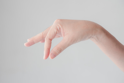 Close up of woman hand picking up something like object isolated on a white background. concept the selection, pick up things, some like virtual business card, credit card or blank paper.