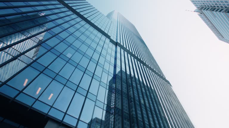 High-rise skyscrapers cityscape low angle dolly shot, financial district looking up modern architecture office buildings and blue sky