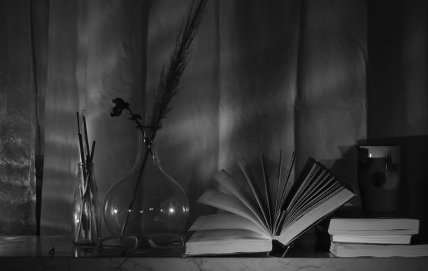 istock Open Book and a vintage vase with a branch and coffee mug,reading,education,learning, international book fair concept, black and white shot 1706746838