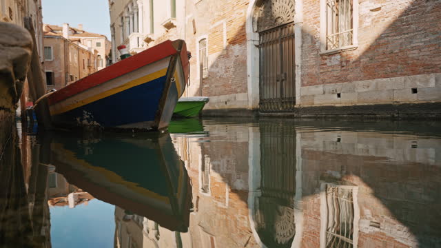 SLO MO Boat Moored on Calm Narrow Canal amidst Old Buildings in Venice