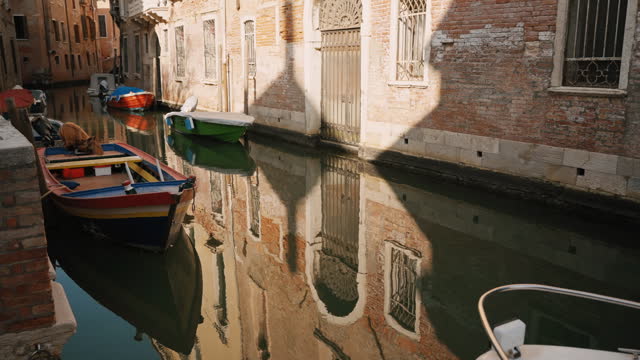 SLO MO Boats Moored on Narrow Canal amidst Old Buildings in Venice
