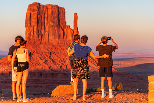 Monument Valley, United States - September 26, 2023:  A family standing looking at the view from an overlook located at Monument Valley, USA.