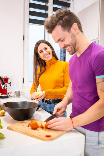 Vertical photo of a happy family cooking healthy food together at home