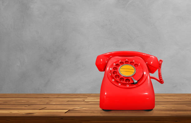 istock Red vintage desk phone on wooden table, cement background. 1706785590