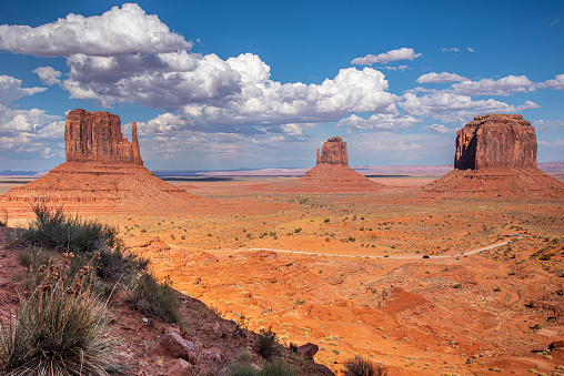 Monument Valley, on the Arizona - Utah border, gives us some of the most iconic and enduring images of the American Southwest.  The harsh empty desert is punctuated by many colorful sandstone rock formations.  It can be a photographer's dream to capture the ever-changing play of light on the buttes and mesas.  Even to the first-time visitor, Monument Valley will probably seem very familiar.  This rugged landscape has achieved fame in the movies, advertising and brochures.  It has been filmed and photographed countless times over the years.  If a movie producer was looking for a landscape that epitomizes the Old West, a better location could not be found.  This picture of the rock formations in the evening light was photographed from John Wayne Point near the Monument Valley Visitor Center north of Kayenta, Arizona, USA.