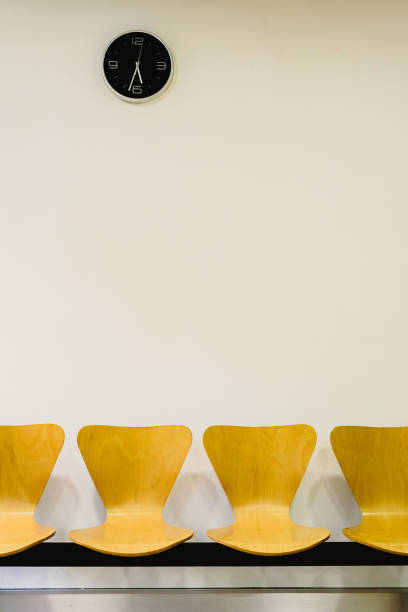 istock Waiting room with empty wooden chairs and wall clock, waiting concept. 1706806835
