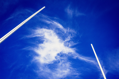 Sky background with white cloud framed between two rugby goal posts