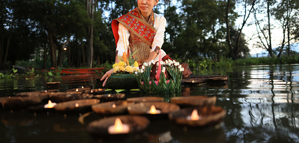 On Loi Krathong day in Thailand, women dressed in traditional Thai attire hold kratongs and float them in the water to pay respect to the Water Goddess during the annual Loi Krathong Traditional Festival held in November.