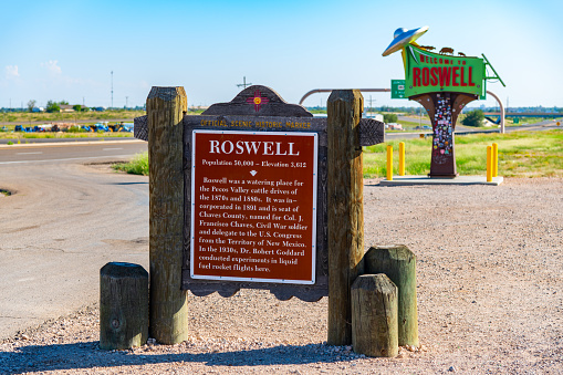 Roswell, United States - September 25, 2023:  A historic marker in the foreground with the welcome sign in  the background to Roswell, New Mexico, the legendary location of a U.F.O. crash in 1947.