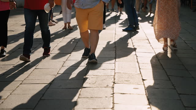 SLO MO Low Section of Tourists Walking on Paved Pathway in Town Square in Venice during Summer Vacation